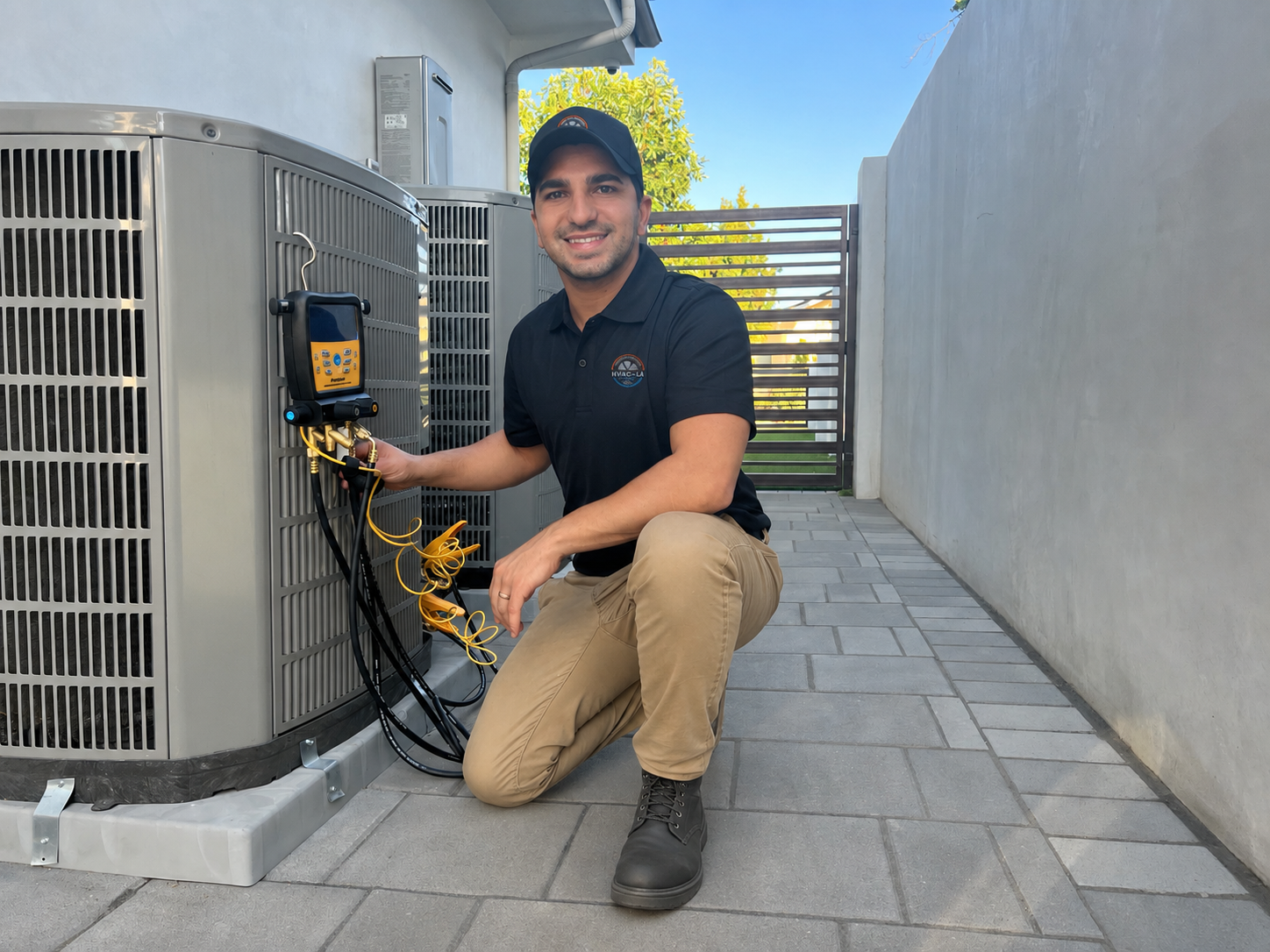 Jacob, lead technician at HVAC in LA, performing diagnostic work on a residential condenser unit